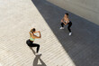 © Alvaro Atalaya/ADDICTIVE STOCK - From above of female athletes in sportswear doing squat exercise while standing in street during workout in city