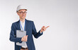 Handsome middle-aged white engineer in hardhat pointing at copy space isolated over white background