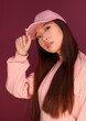 © Victor Torres/ADDICTIVE STOCK - Portrait of serious young asian woman in the studio wearing pink clothes over garnet background