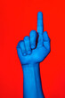 © Angela Rober/ADDICTIVE STOCK - Man's blue hand making the number one sign over red background. Isolated vertical photo