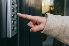 Crop Anonymous Female In Warm Coat Pressing Entry Phone Button While Standing Near Building Entrance Door On Clear Autumn Day