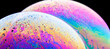 © David Espejo/ADDICTIVE STOCK - Panoramic view of closeup bubble textured backdrop representing colorful planets with wavy lines on round shaped surface on black background