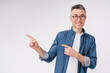 Cheerful caucasian middle-aged man in casual clothes pointing at copy space isolated over white background