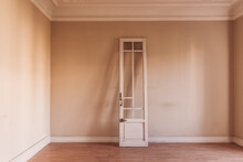 White Wooden Door With Shabby Surface Placed In Old Empty Room At Daytime