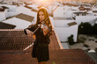 © Joseph Table/ADDICTIVE STOCK - Young beautiful female musician in stylish mini dress holding acoustic violin and standing on rooftop in residential suburb and looking away on sunny evening