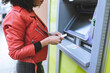 © Jose Carlos Cerdeno/ADDICTIVE STOCK - Anonymous african American female standing near ATM and inserting credit card while smiling widely and looking away