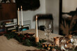 © Joy Zamora/ADDICTIVE STOCK - Cozy Xmas interior in natural rustic style with table decorated with burning candles and decorative elements in room with glowing garland