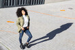 © Jose Carlos Cerdeno/ADDICTIVE STOCK - From above of expressive young black lady with Afro hairstyle in stylish clothes standing on paves street and smiling on sunny day
