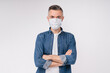 Handsome mature caucasian man in casual attire in medical mask against Covid 19 isolated over white background