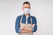 Confident caucasian mature barista in medical protective mask against Covid 19 with arms crossed isolated over white background