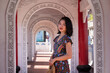 © Juan Alberto Ruiz/ADDICTIVE STOCK - Side view of delighted Asian female traveler standing in arched passage of Cikang Overpass bridge and looking at camera while enjoying sightseeing during summer vacation in Taiwan