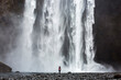 © Josu Torrealday/ADDICTIVE STOCK - Back view of unrecognizable traveler standing near amazing waterfall in mountains during vacation in Iceland