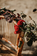 High Angle Of Vintage Wicker Chair Decorated With Dried Rose Flowers And Placed In Garden On Sunny Day For Wedding Celebration