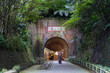 © Juan Alberto Ruiz/ADDICTIVE STOCK - Female tourist in dress standing in front of entrance in Old Baiji Tunnel during summer vacation in Taiwan and looking at camera