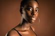 © Luis Manuel Munoz/ADDICTIVE STOCK - Slender black woman with short hair standing against brown background looking at camera