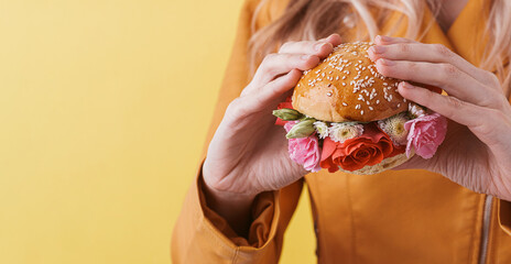 Poster - burger with fresh flowers in female hands