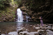 © Juan Alberto Ruiz/ADDICTIVE STOCK - Back view of unrecognizable female tourist standing on rocks and taking picture of majestic Tiemu Waterfall during vacation in Taiwan