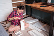 © Juan Alberto Ruiz/ADDICTIVE STOCK - High angle of focused ethnic female using hammer for nailing wooden dowels while assembling new furniture in apartment