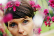 © Marianna Jaszczuk/ADDICTIVE STOCK - Crop pensive adult female with short hair recreating in green garden near bright blossoming flowers and looking at camera