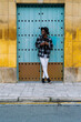 © Luis Manuel Munoz/ADDICTIVE STOCK - Full body of African American male in trendy outfit and sunglasses standing with crossed legs near doorway