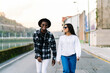 © Luis Manuel Munoz/ADDICTIVE STOCK - Young content multiracial partners in trendy clothes and sunglasses talking while looking at each other and strolling on city roadway