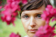 © Marianna Jaszczuk/ADDICTIVE STOCK - Crop pensive adult female with short hair recreating in green garden near bright blossoming flowers and looking at camera