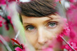 © Marianna Jaszczuk/ADDICTIVE STOCK - Crop pensive adult female with short hair recreating in green garden near bright blossoming flowers and looking at camera