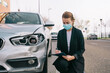 © Older Garcia/ADDICTIVE STOCK - Side view of unrecognizable female insurance agent in formal outfit and protective mask writing protocol near damaged car parked on street after accident