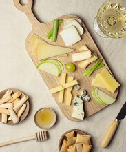 From Above Various Cut Cheese On Wooden Board With Croutons Placed On Table