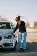 © Older Garcia/ADDICTIVE STOCK - Full body of upset young female driver in casual outfit having phone conversation while standing on road and inspecting damages on modern car after crash