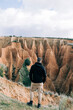 © Nacho Zaitsev/ADDICTIVE STOCK - Back view of unrecognizable tourist admiring ravine from mount under cloudy sky in daylight
