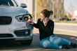 © Older Garcia/ADDICTIVE STOCK - Full body of upset young female driver in casual outfit having phone conversation while sitting on road and inspecting damages on modern car after crash