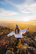 © Ruben Soto/ADDICTIVE STOCK - From above back view of anonymous female tourist in outerwear strolling on rough stones in mountains under cloudy sky at shiny dawn in back lit