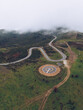 © Ruben Soto/ADDICTIVE STOCK - Spectacular drone view of curved serpent road near round concrete helipad on grassy rural valley on summer day running through green hills in highlands