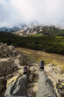 © Ruben Soto/ADDICTIVE STOCK - Crop anonymous tourist in casual wear lying on rough land against mountains during trip in Spain