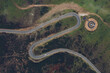© Ruben Soto/ADDICTIVE STOCK - Spectacular drone view of curved road near round concrete helipad on grassy rural valley on summer day running through green hills in highlands