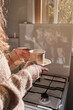 © Philippe Degroote/ADDICTIVE STOCK - Cropped unrecognizable female with hot beverage in cup enjoying morning at home in the kitchen near windows
