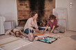 © Philippe Degroote/ADDICTIVE STOCK - Female artist and teenager sitting on floor with dog and creating painting together while enjoying weekend in house near fireplace