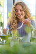 © Philippe Degroote/ADDICTIVE STOCK - Happy young blonde female in casual clothes enjoying tasty oriental dish served in bowl with chopsticks while having lunch in cafe