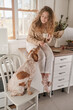 © Philippe Degroote/ADDICTIVE STOCK - Charming female sitting on counter with cup of morning coffee and looking at cute Setter dog during breakfast at home