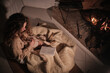 © Philippe Degroote/ADDICTIVE STOCK - From above of tender female sitting under blanket and cuddling adorable Setter dog while reading notes in diary and enjoying cozy evening near fireplace