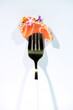 © Victor Prieto/ADDICTIVE STOCK - Piece of tasty salmon sashimi decorated with caviar and herbs on fork against white background