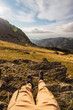 © Ruben Soto/ADDICTIVE STOCK - Crop anonymous tourist in casual wear lying on rough land against mountains during trip in Spain