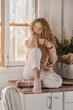 © Philippe Degroote/ADDICTIVE STOCK - Thoughtful female sitting on counter in kitchen and enjoying aromatic coffee in morning at home