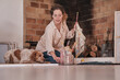 © Philippe Degroote/ADDICTIVE STOCK - Smiling female artist cleaning paintbrush while sitting on floor in cozy house with fluffy Setter dog