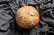 © Txema Gerardo/ADDICTIVE STOCK - Top view of appetizing artisan round bread loaf with golden crispy crust placed on gray cloth