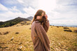© Ruben Soto/ADDICTIVE STOCK - Young gentle female traveler in casual outfit looking at camera against mount in sunlight in Spain