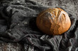 © Txema Gerardo/ADDICTIVE STOCK - From above of appetizing freshly baked whole round bread loaf arranged near wooden spoon on gray cloth sprinkled with flour