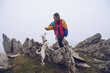 © Ruben Soto/ADDICTIVE STOCK - Female owner feeding white dog with treat while standing on rocks in highlands on foggy day