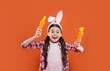 © be free - happy teen girl in funny bunny ears for easter holiday hold carrot, easter fun